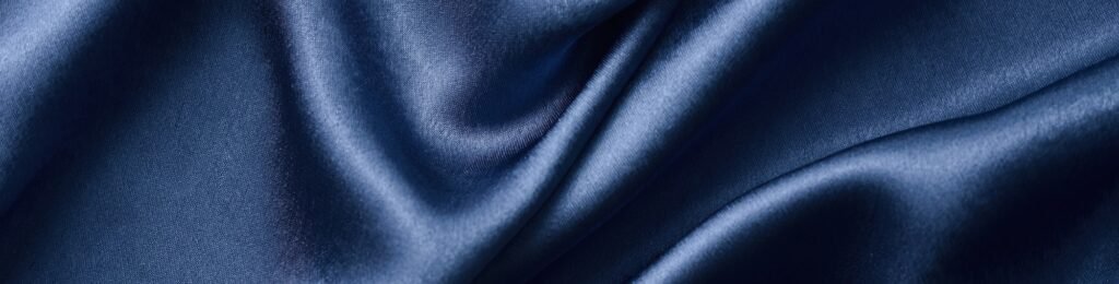 Silver silk background with a folds. Abstract texture of rippled silk surface, wide long banner